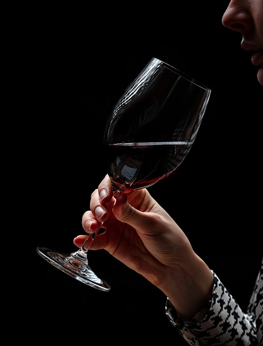 Uma mulher desfruta de um copo de vinho num ambiente íntimo para celebrar o Natal no Dans le Noir ?