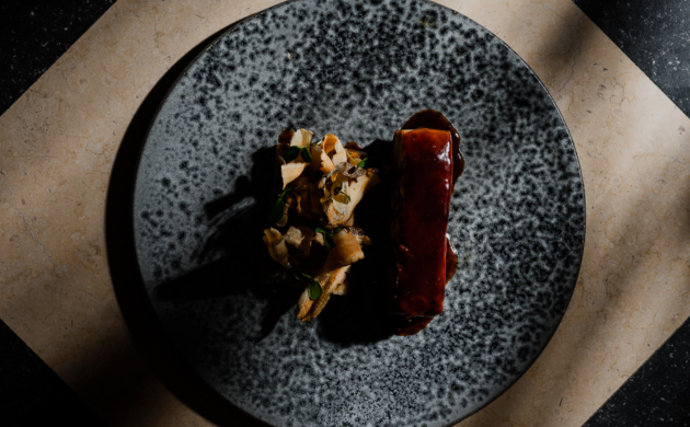 Gourmet plated dish with meat and vegetables on a textured plate, fine dining presentation in a Lisbon sensory restaurant experience